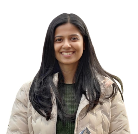 Amala Nair, Product Manager in beige blazer and dark green top with professional smile